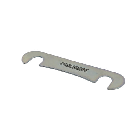 Brake caliper shim shown next to a brake pad to compare shape and bolt hole spacing